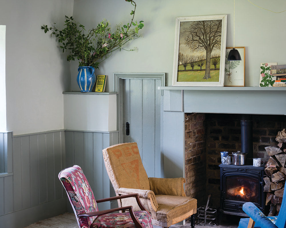 Cromarty 285 paint by Farrow & Ball in a cottage living room with stove and panelling