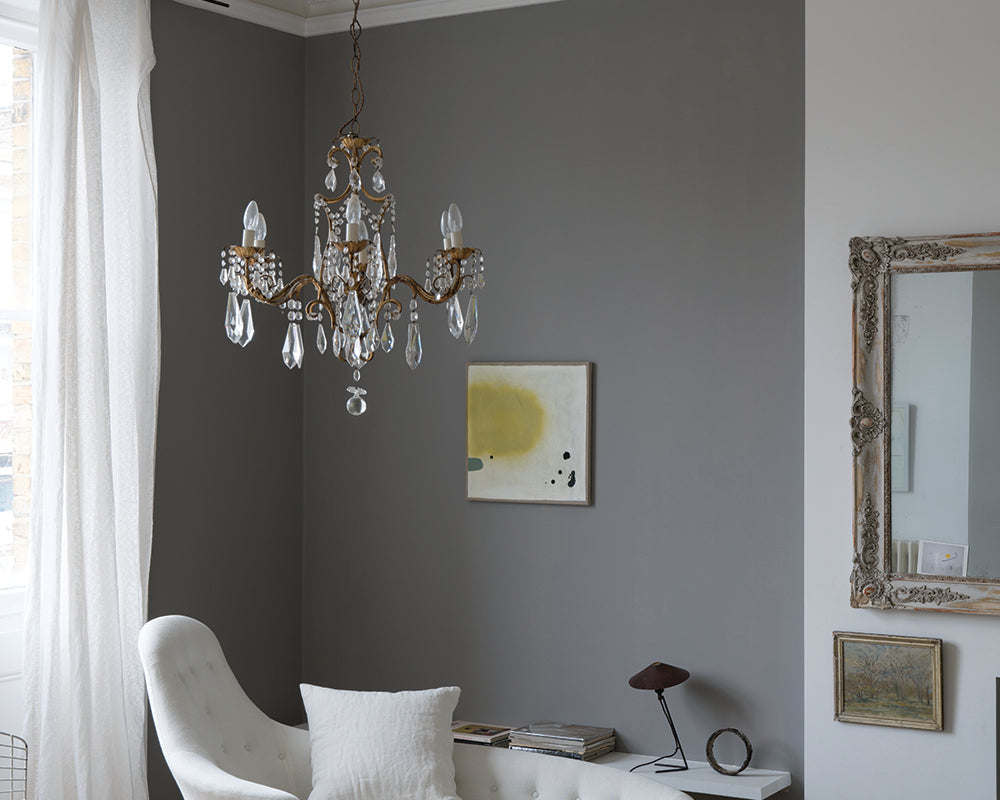 Worsted 284 paint by Farrow & Ball on cladding in a living room with crystal light fitting