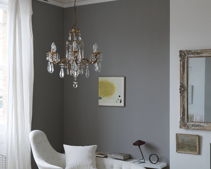 Worsted 284 paint by Farrow & Ball on cladding in a living room with crystal light fitting
