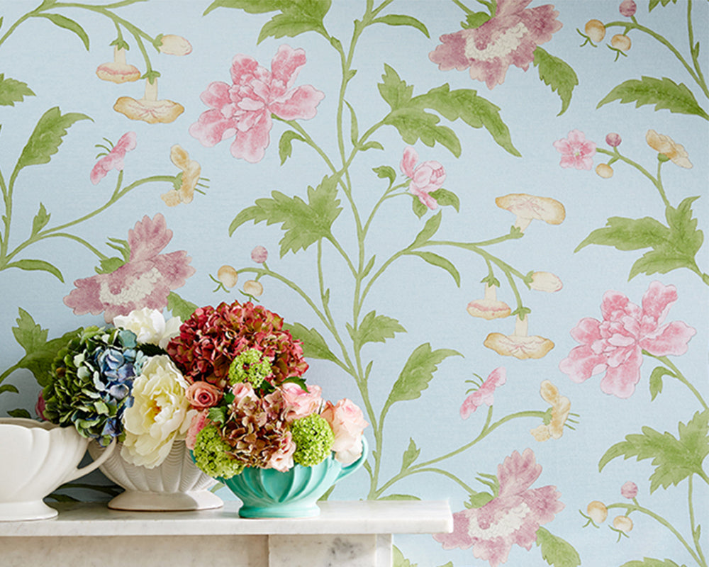 Little Greene China Rose Wallpaper in Blue Lustre in a marble fireplace background with flower arrangement