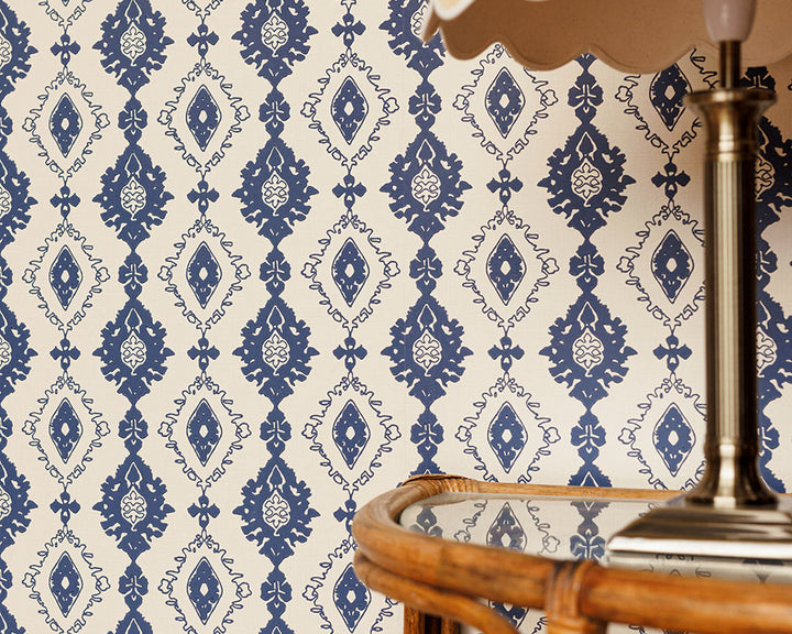 Barneby Gates Kilim Wallpaper close up with a lamp and side table