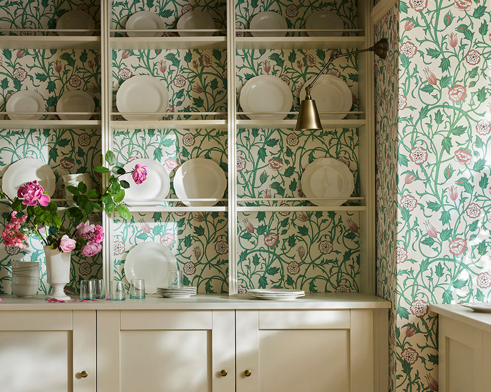 Kitchen with Little Greene May's Tulip floral wallpaper and shelves displaying plates and decor.