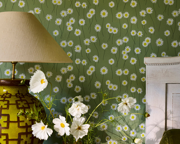 Little Greene Moon Daisies floral wallpaper with daisies, a lamp, and a vase with cosmos flowers on the green background wallpaper