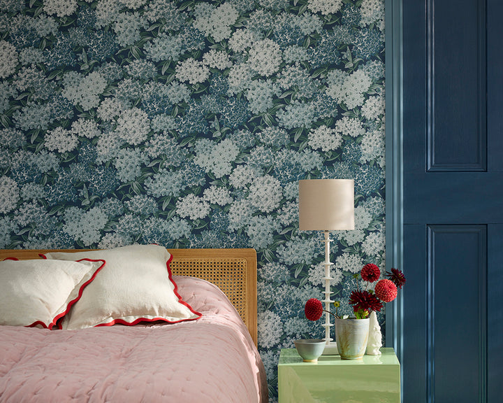 Bedroom with Little Greene Rhododendron Walk floral wallpaper, bed, and lamp