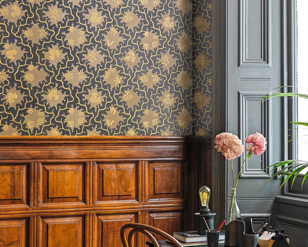 Decorative Cole & Son Moss Trellis Wallpaper with floral pattern in a room with wooden furniture and a window.