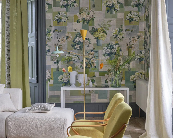 Living room with floral wallpaper, Designers Guild Celadon Vase Wallpaper - Grasscloth, green armchair, and white sofa.