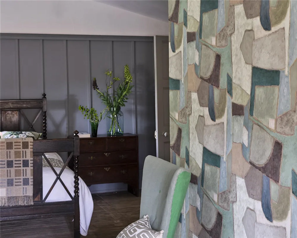 Bedroom with wooden bed, dresser, and patterned wall with Designers Guild Clay Collage Wallpaper