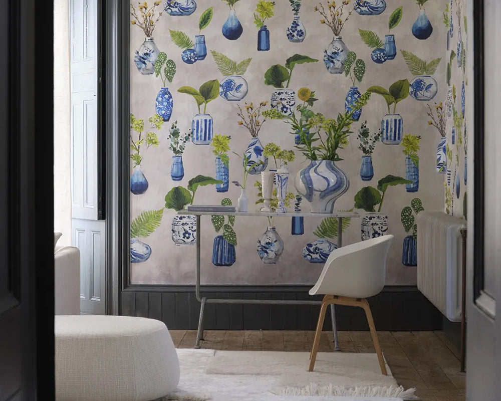 Living room with floral wallpaper, Designers Guild Kawana Wallpaper, featuring blue vases and green leaves.