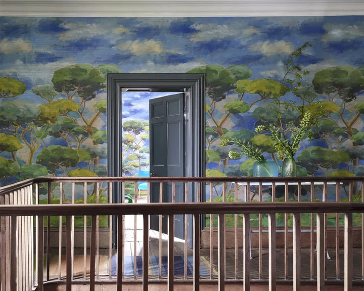 Landing space with wooden railing and decorative Designers Guild Matsu Wallpaper - Grasscloth -  with trees and sky.