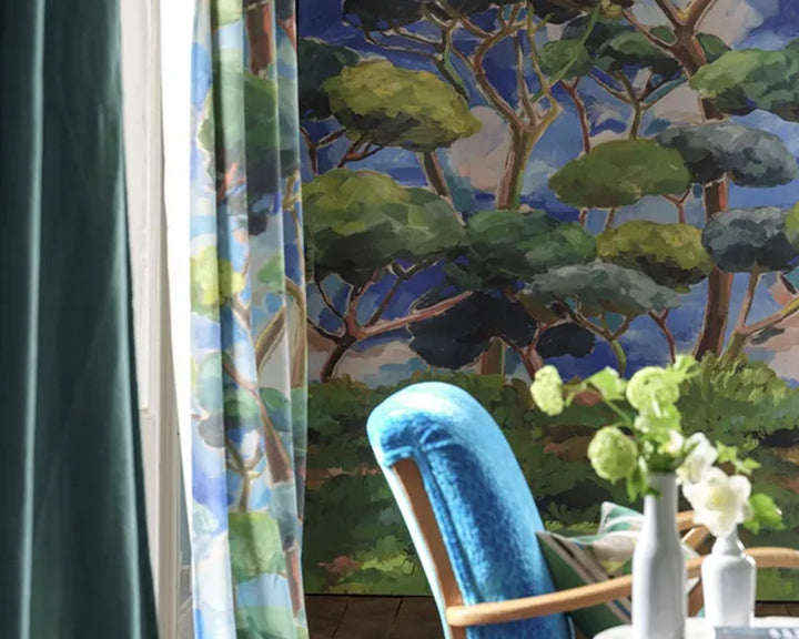 Room with a blue chair, white vase with flowers, and a large window with a scenic backdrop, Designers Guild Matsu Wallpaper