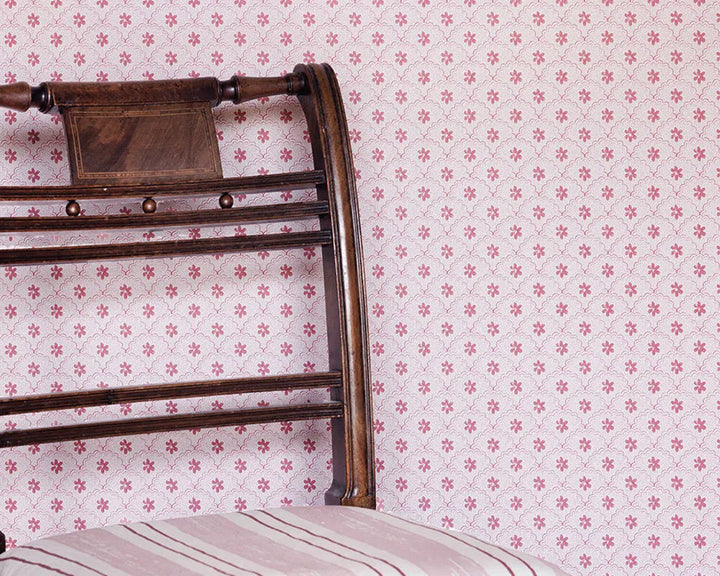 Barneby Gates Daisy Scallops Wallpaper in red/pink detail with a chair