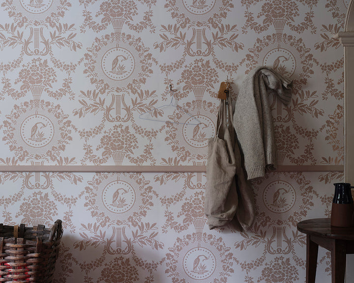 Farrow and Ball Purnon 6201 Wallpaper in a hallway with a storage basket and hanging coats