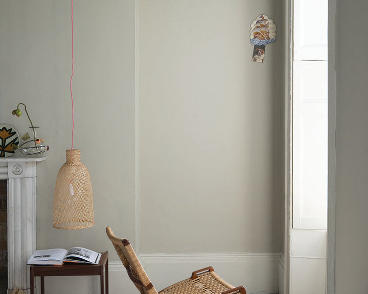 Shadow White 282 paint by Farrow & Ball in a living room with woven chair