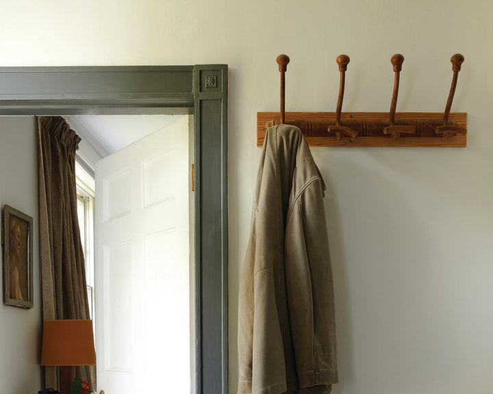 Strong White 2001 paint by Farrow & Ball in a hallway with coat hooks