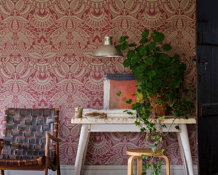 Farrow and Ball Orangerie Wallpaper in a hallway with a chair and plants