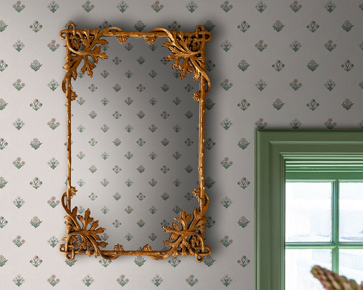 Decorative gold mirror on a wall with patterned Sandberg Amy Wallpaper
