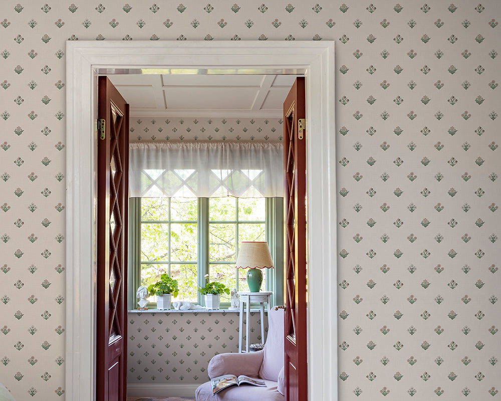 Room with patterned Sandberg Amy Wallpaper, open door revealing a sunlit room with plants and a lamp.