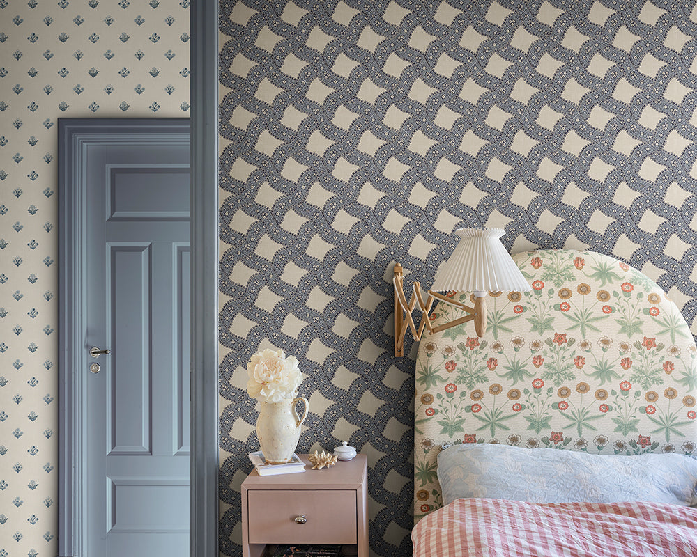 Room interior with patterned Sandberg Annie Wallpaper, floral headboard, and nightstand.