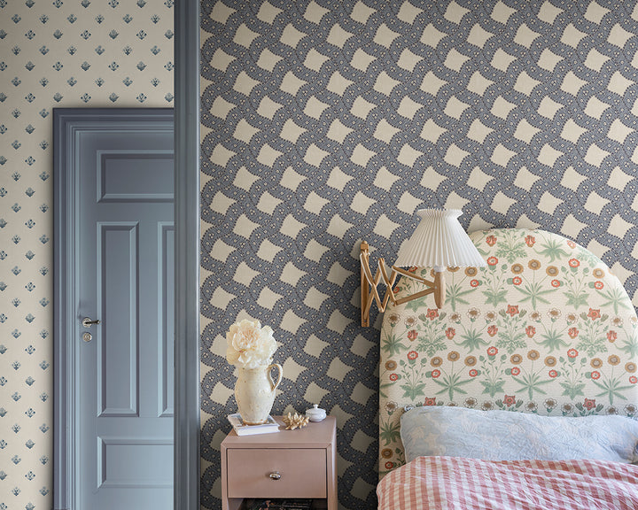 Room interior with patterned Sandberg Annie Wallpaper, floral headboard, and nightstand.