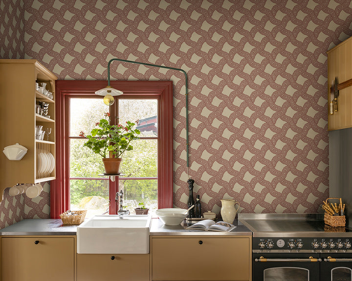 Kitchen with red geometric Sandberg Annie Wallpaper, white sink, and wooden cabinets.