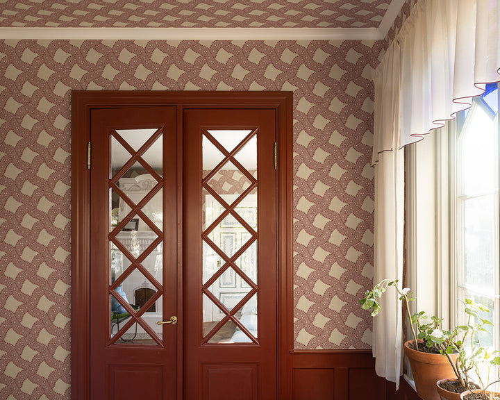 Wooden double doors with glass panels in a room with patterned Sandberg Annie Wallpaper and a window.