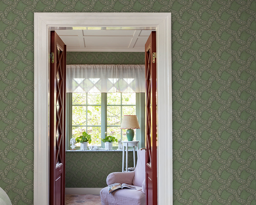 Decorative interior with green Sandberg Annie Wallpaper, a window with white curtains, and a lamp.