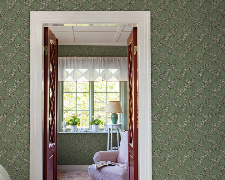 Decorative interior with green Sandberg Annie Wallpaper, a window with white curtains, and a lamp.