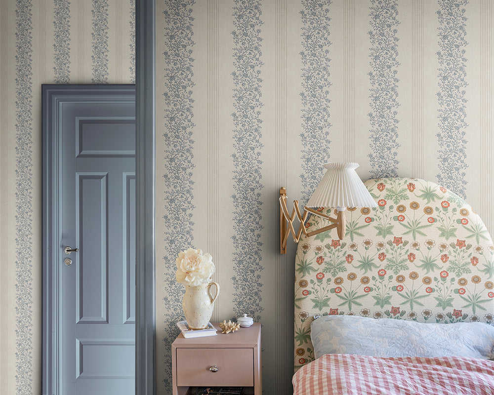 Sandberg Natalie Wallpaper in a bedroom interior with floral headboard, nightstand, and light blue door