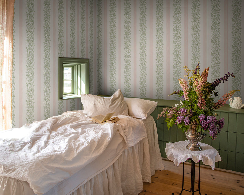 Sandberg Natalie Wallpaper in a bedroom with a bed with white bedding, and a small table with flowers.