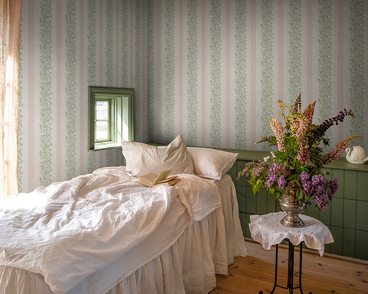 Sandberg Natalie Wallpaper in a bedroom with a bed with white bedding, and a small table with flowers.