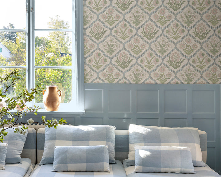 Sandberg Rosa Wallpaper in a living room with a sofa, decorative pillows, and flowers