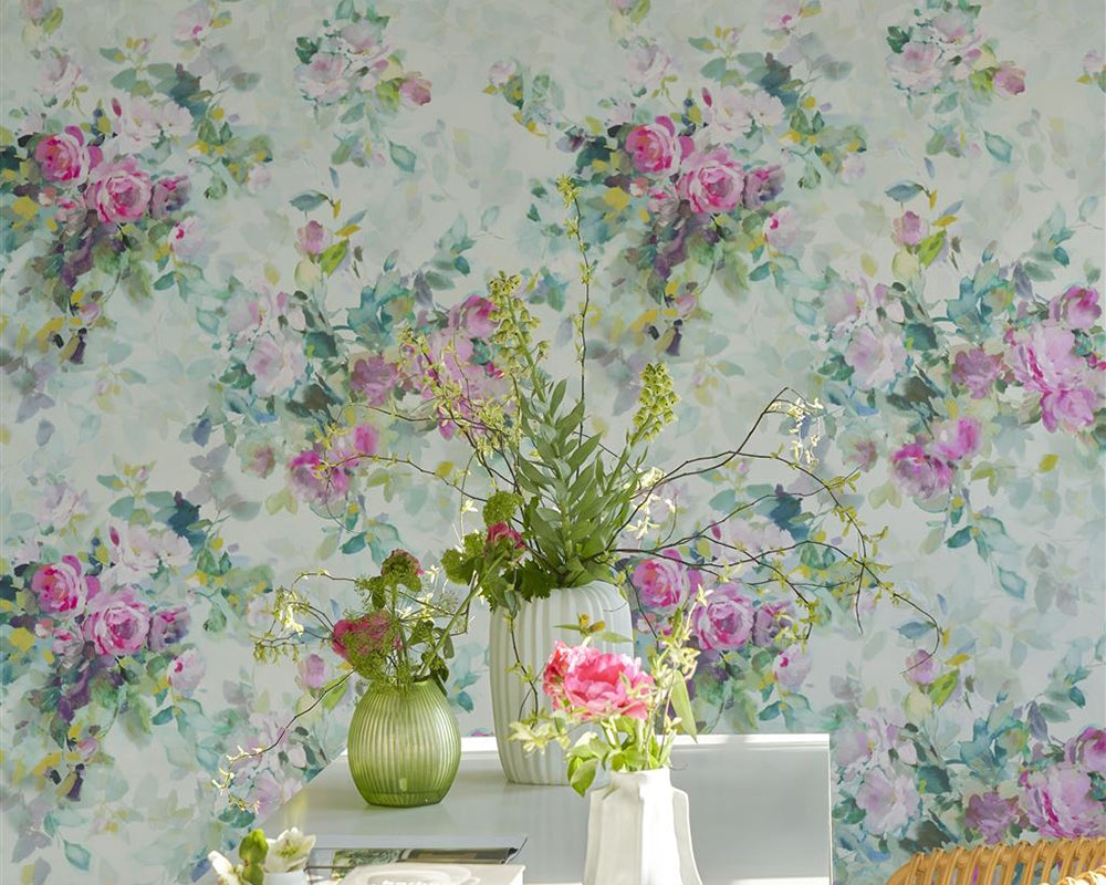 Designers Guild Bouquet De Roses Wallpaper behind a desk with flowers