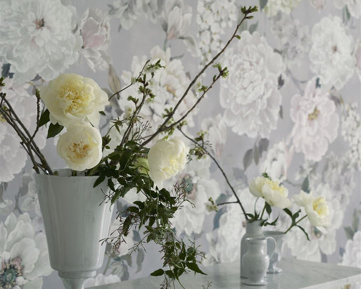 Designers Guild Fleur Blanche Wallpaper on a wall behind flowers
