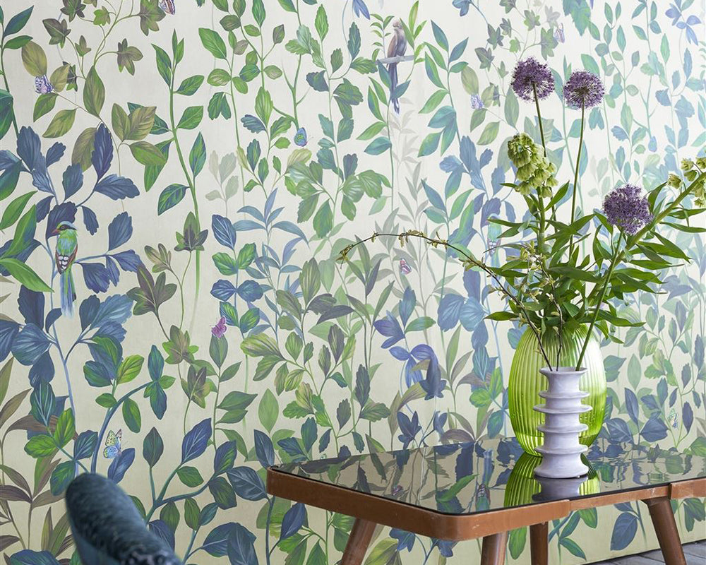 Designers Guild Voliere Wallpaper on a wall behind a chair and table