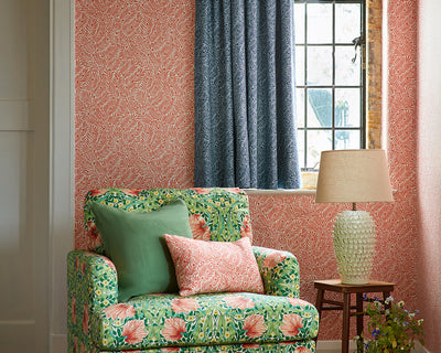 Morris & Co Yew & Aril Wallpaper in Watermelon in a livingroom set up close up
